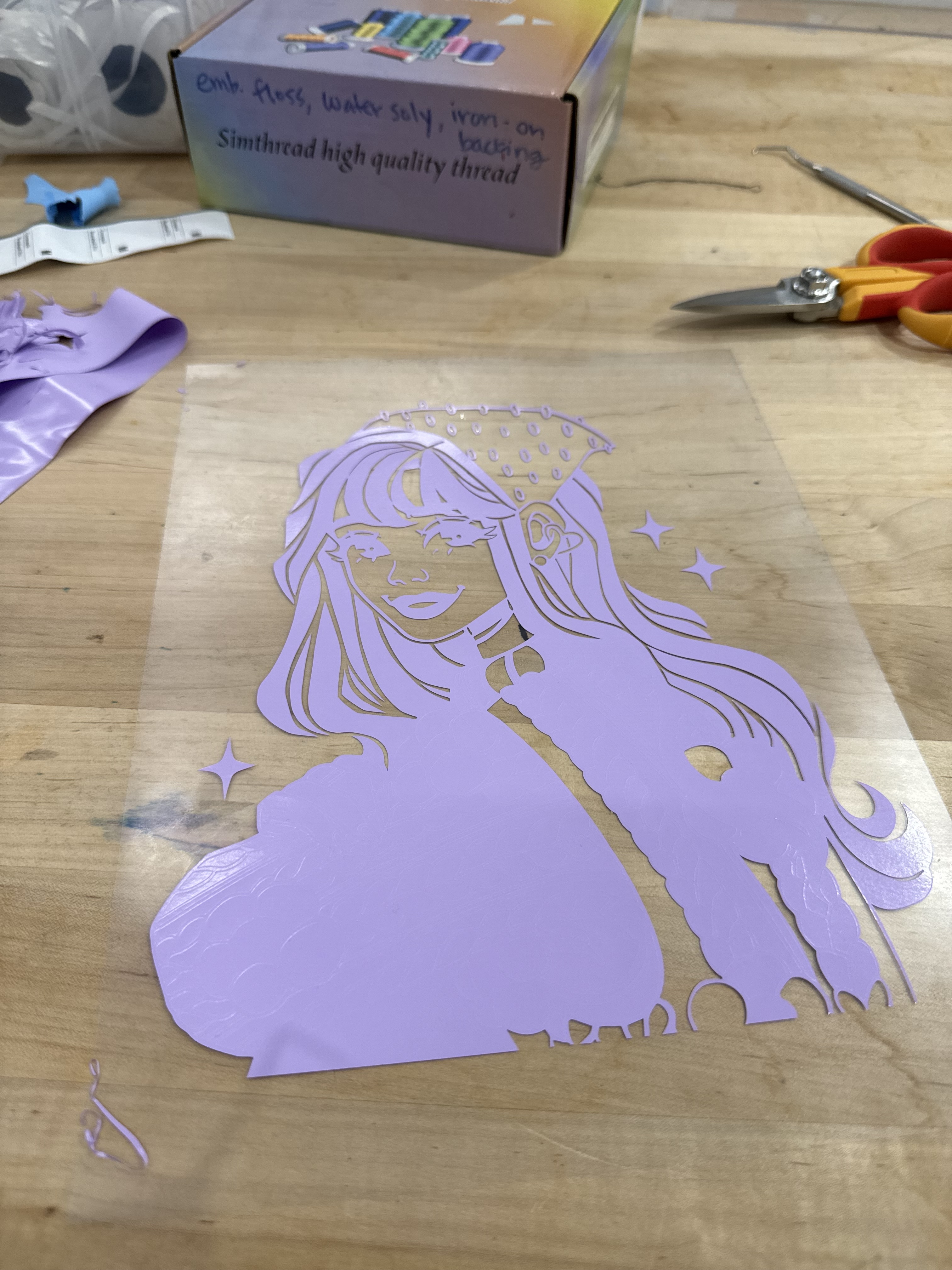 A photo of a heat-transfer purple vinyl that has been cut and partially weeded. The image is of a drawing I made.