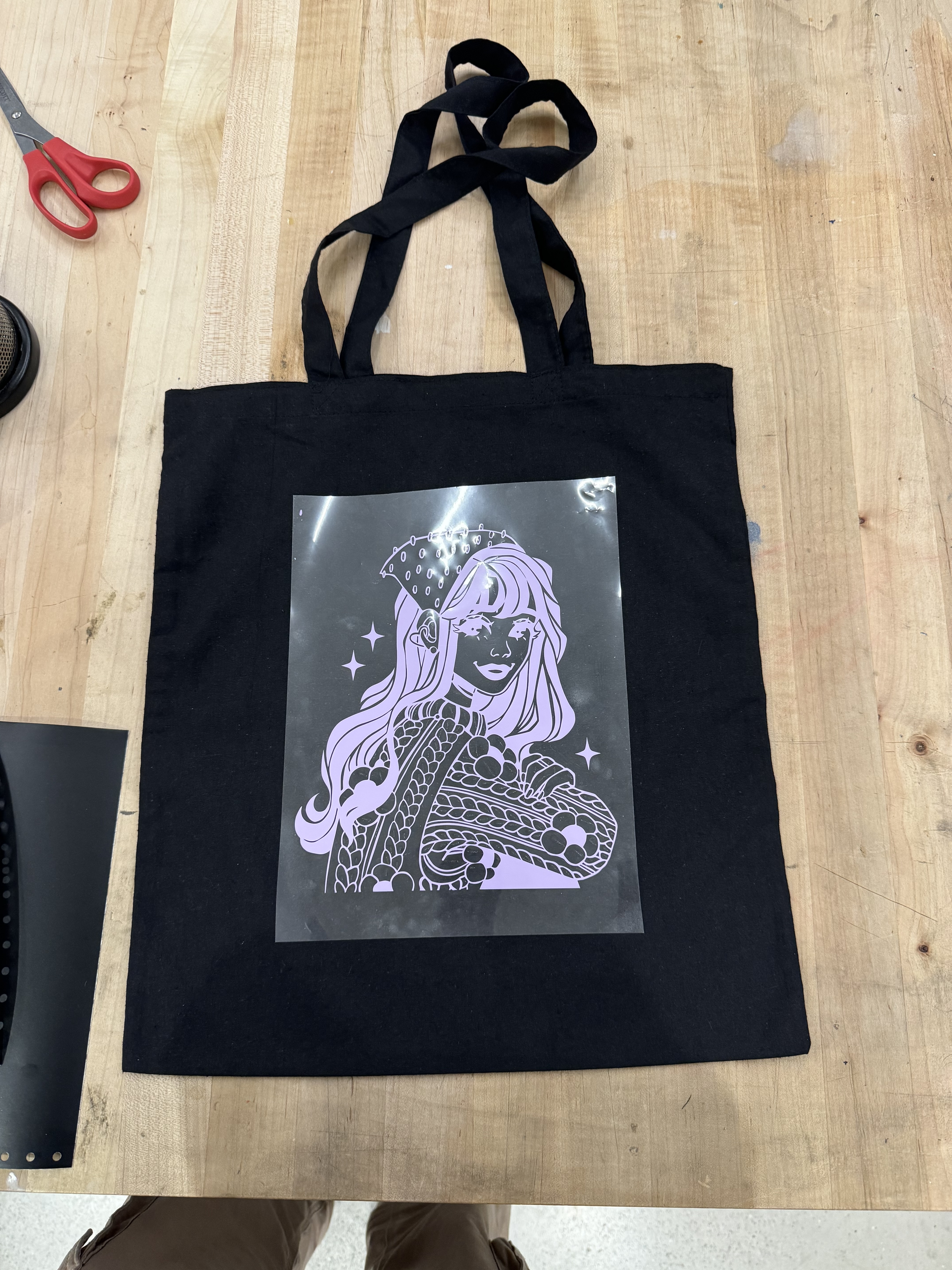 The heat-transfer purple vinyl has been pressed onto a tote bag.